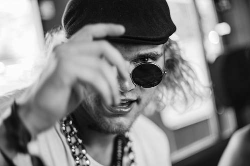 human greyscale photography of man wearing newsboy cap person