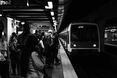 people group of people waiting for the train in grayscale photography subway