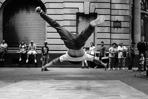 people jumping man in grayscale photography person
