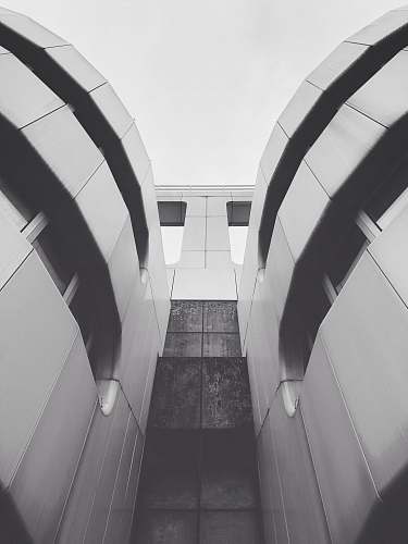 banister low angle and grayscale photography of building during daytime handrail