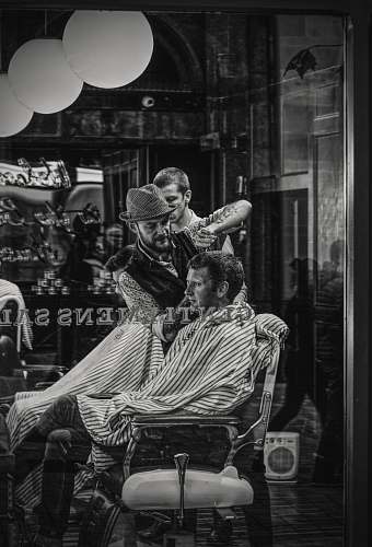 human man cutting a person's hair on chair person