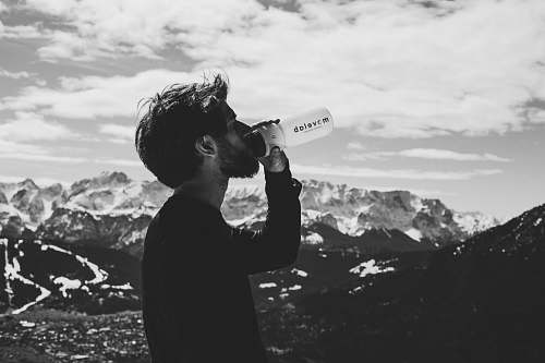 person man drinking water on top of mountian human