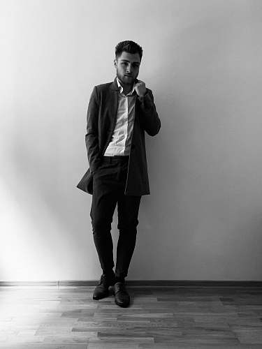 clothing man leaning beside wall apparel
