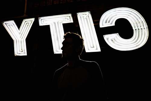 human man standing in front of CITY light signage portrait
