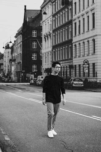apparel man walking on road by buildings clothing