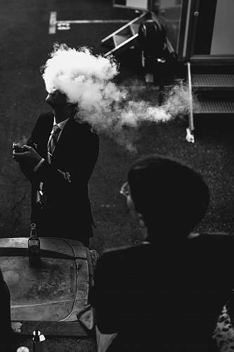 person man wearing black formal coat smoke