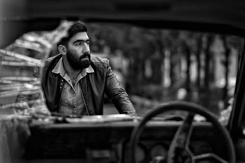 human man wearing jacket standing beside vehicle face