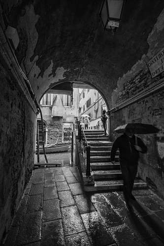 path man with umbrella walking in tunnel walkway