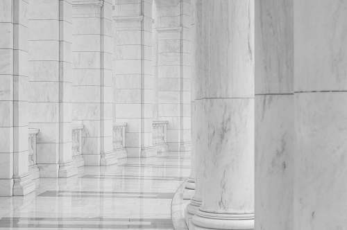 grey minimalist photography of hallway between columns arlington national cemetery