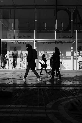 human people walking down the street near glass window building pedestrian
