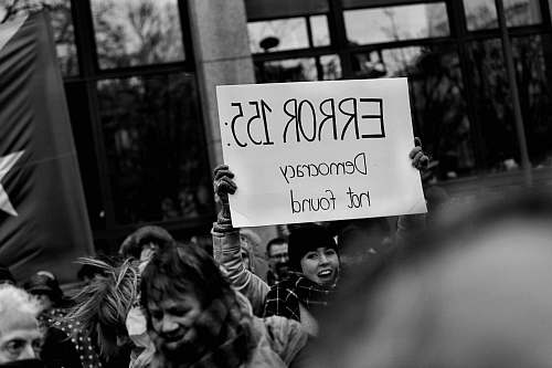 person person holding a white Error 155 signage people