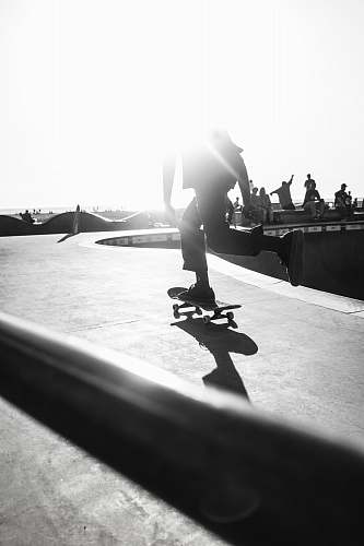 human person riding skateboard on grayscale photography person