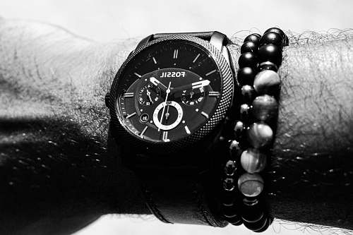 wristwatch person wearing round Fossil chronograph watch with link band displaying 01:47 time black