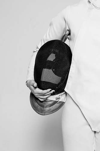 apparel person wearing white fencing suit holding black mask inside room clothing