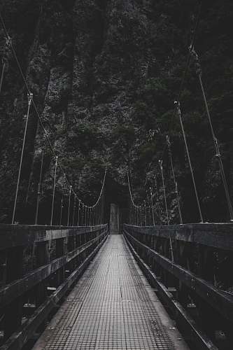 grey photo of bridge near mountain bridge
