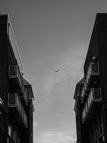 grey plane between building asphalt