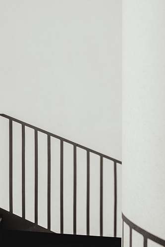 grey shadow of stair rails on white painted wall shadow