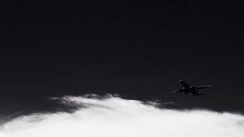 grey silhouette photo of flying plane flying