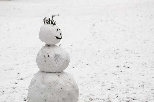 grey snow made snowman on snow covered field during daytime outdoors