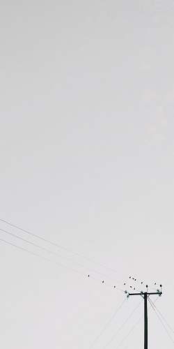 grey transmission post under white clouds lamppost