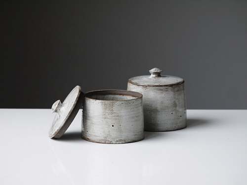 grey two grey containers on wooden table pottery