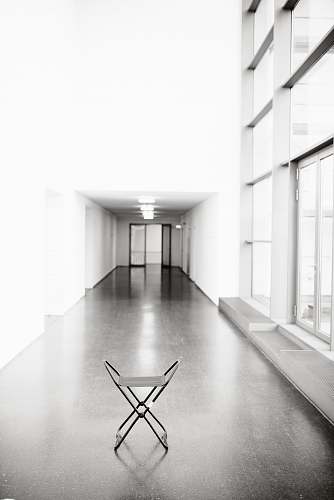 flooring vacant white chair in between hallway of building floor