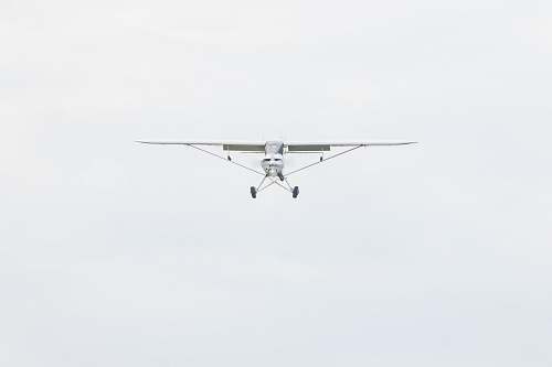 aircraft white monoplane flying during daytime airplane