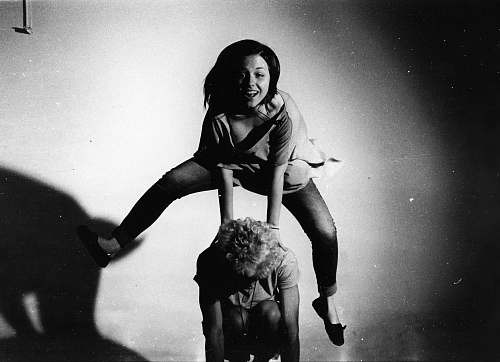 person woman jumping on other person's back in grayscale photography people