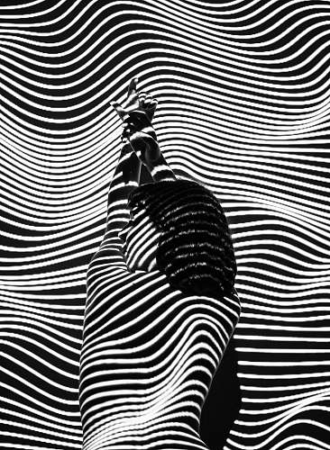 white woman raising both arms with stripe light color black
