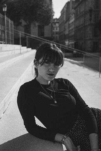 apparel woman sitting on stairs grayscale photo banister