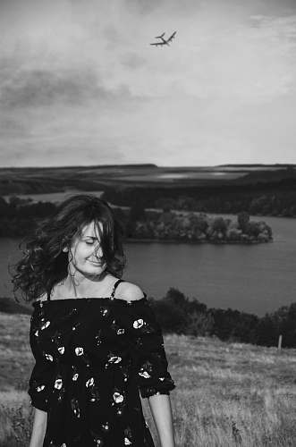 nature woman standing on hill top near lake with airplane flying above human