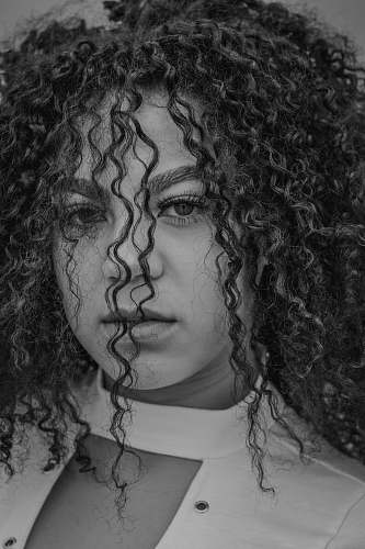 person woman with curly hair looking straight face