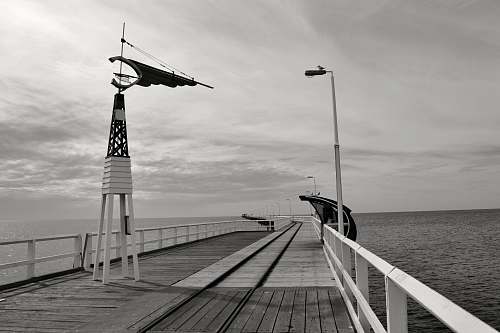 dock wooden wind vane on bridge near the body of water pier