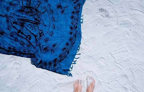 summer blue and black floral scarf on white sand feet