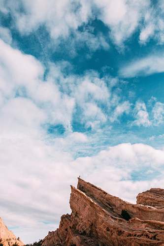 cliff person standing on mountain ledge outdoors