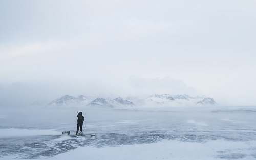 mountain photo of person walking on snow iceland