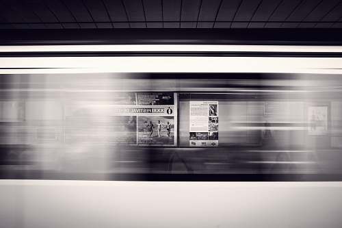 subway A long-exposure shot of a moving subway train and advertisement posters at the station train