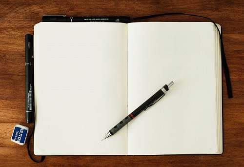 paper black and silver retractable pen on blank book blank