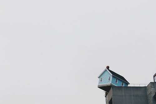 house blue concrete storey house on top of building at daytime balance