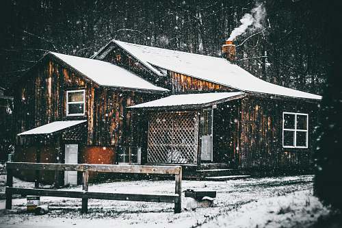 snowing brown wooden house covered by snow cabin