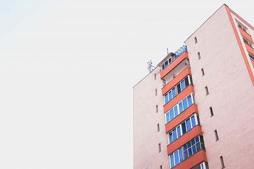 minimal orange and blue high-rise building during clear sky pink
