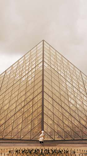 paris person standing in front of brown glass building during daytime france