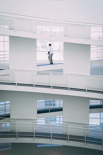 grey person walking on stairs inside building during daytime balcony