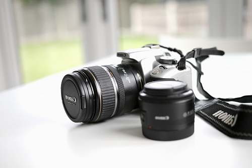 electronics black Canon DSLR camera on white surface canon