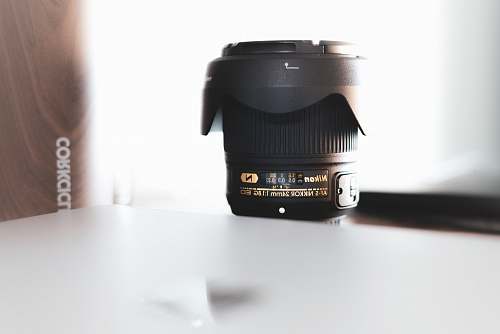 electronics black Nikon camera zoom lens on table camera lens