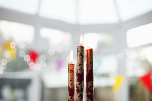 light three brown-and-red candles on top of table interior design