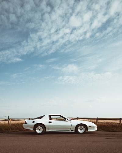 vehicle silver coupe under cloudy sky white car