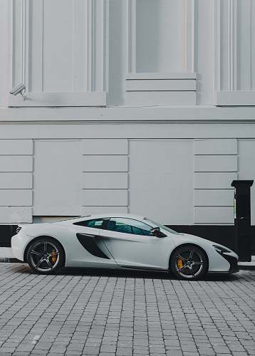 vehicle white and black coupe beside white building paint manchester