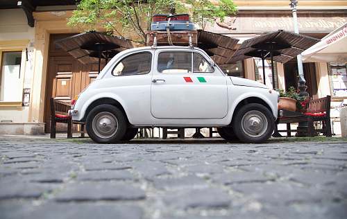 suitcase white coupe parking near building luggage