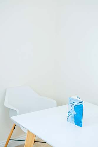 table blue and white hardbound book on white wooden table furniture